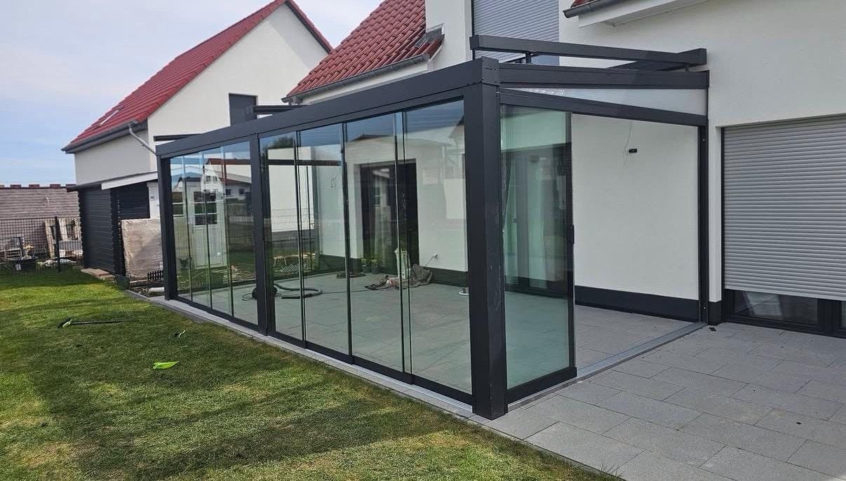 Nachher: Terrassendach mit rahmenlosen Glasschiebewänden über Eck
