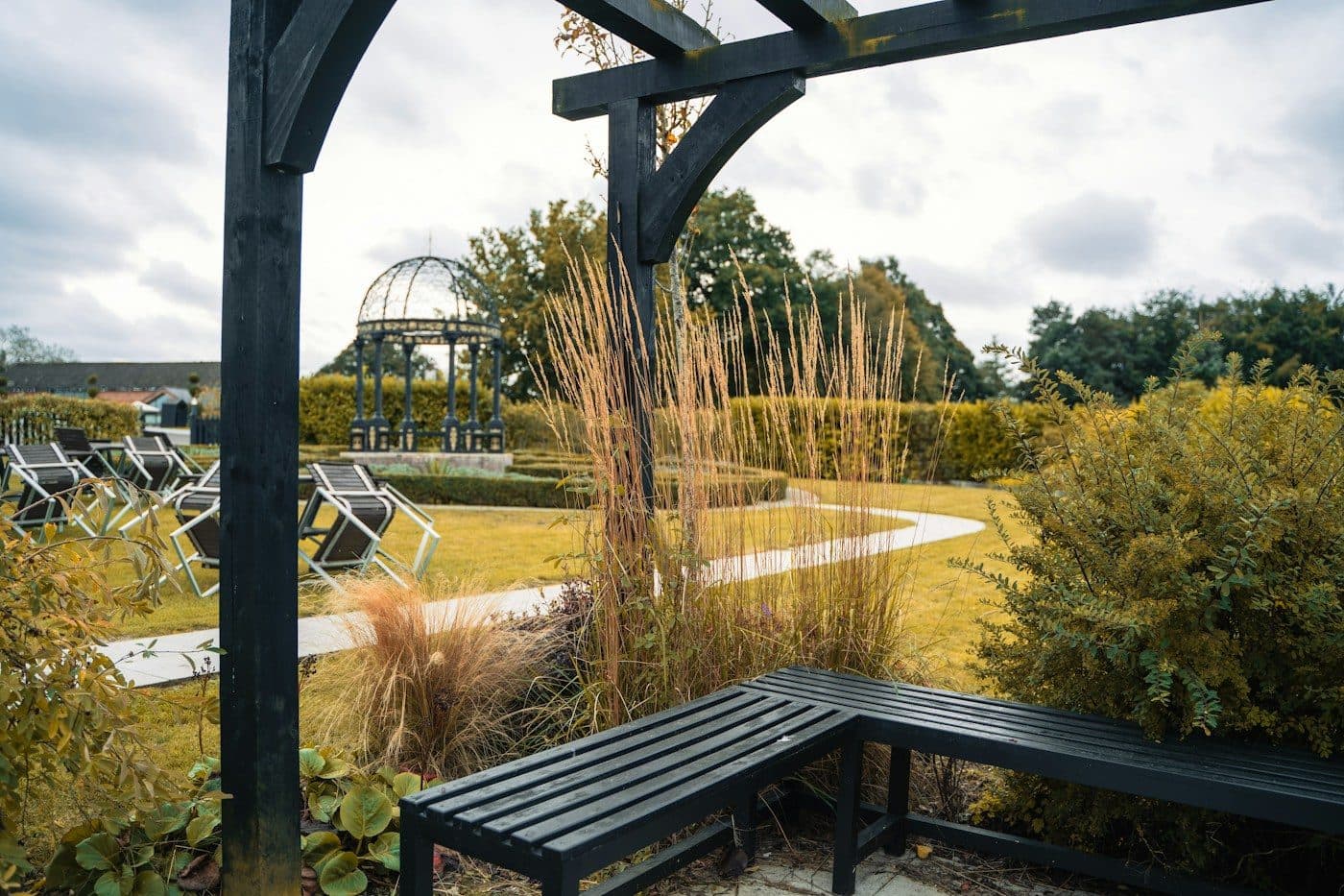 Freistehende Pergola mit Sitzbank in einem Garten