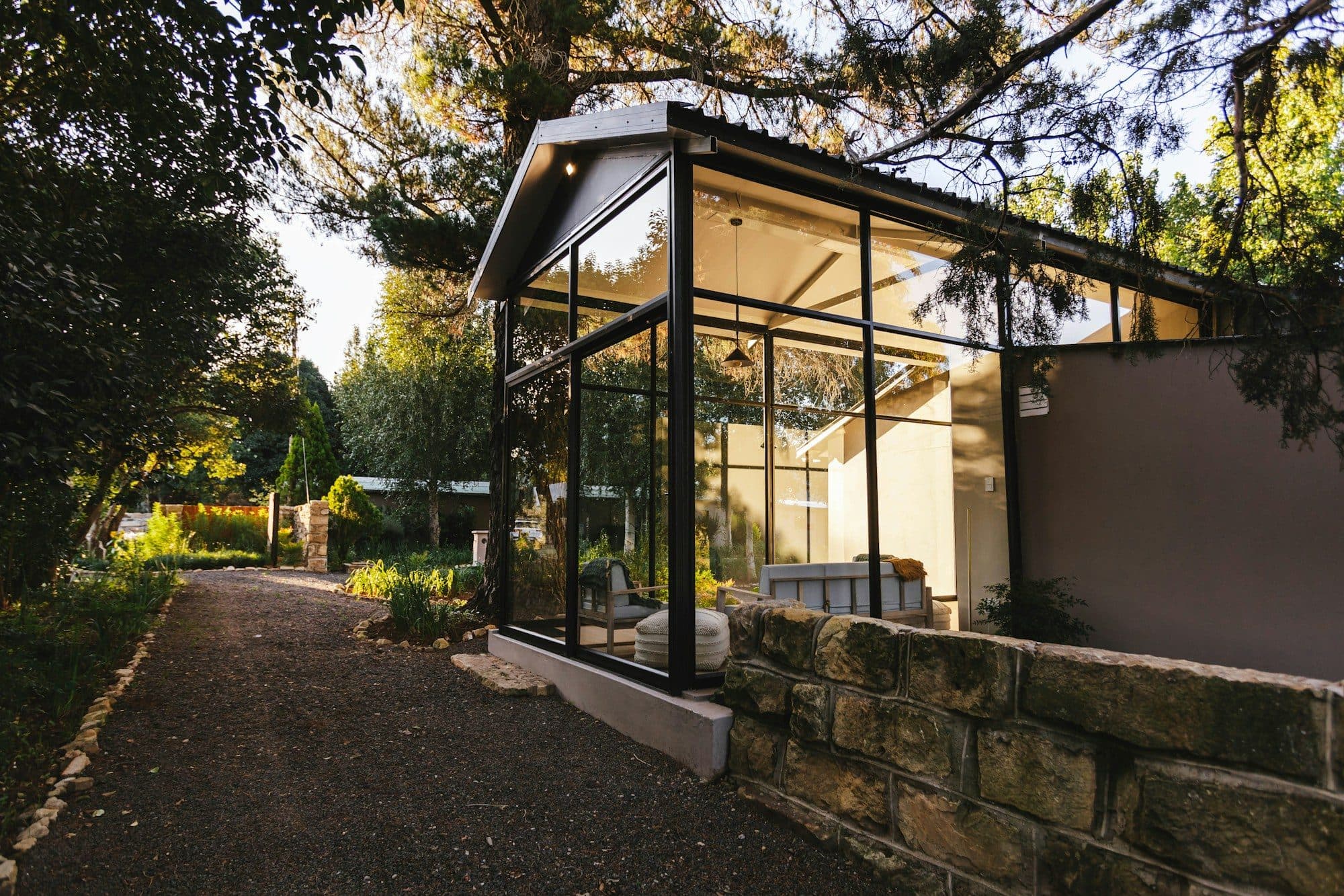 Moderner verglaster Gartenraum mit Sitzecke am Wohnhaus