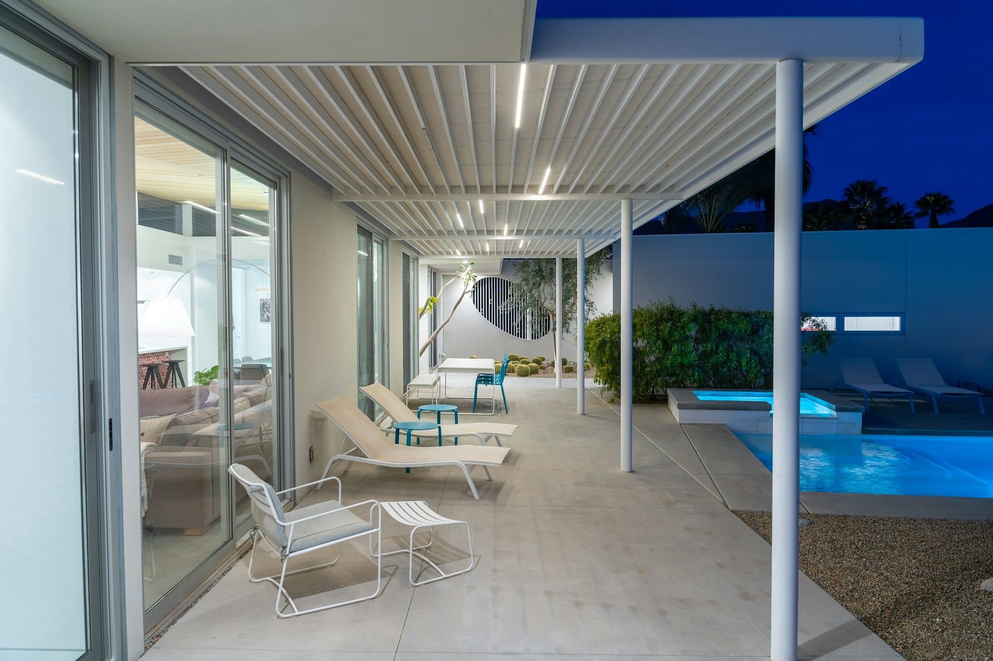 Weißes Lamellendach an einem modernen Haus mit Pool in der Abenddämmerung