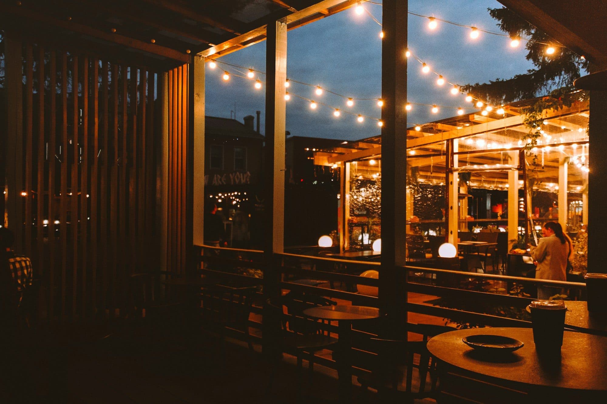 Überdachte Terrasse mit Lichterkette und warmem Licht am Abend